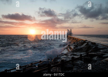 Aberystwyth, Wales, UK. 11. August 2014. Gepeitscht bis durch den Sturm namens Bertha Meer stürzt Wellen gegen den Leuchtturm in Aberystwyth bei Sonnenuntergang. Bildnachweis: Jon Freeman/Alamy Live-Nachrichten Stockfoto