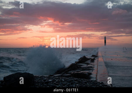 Aberystwyth, Wales, UK. 11. August 2014. Gepeitscht bis durch den Sturm namens Bertha Meer stürzt Wellen gegen den Leuchtturm in Aberystwyth bei Sonnenuntergang. Bildnachweis: Jon Freeman/Alamy Live-Nachrichten Stockfoto