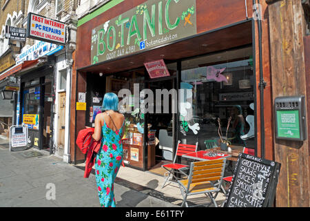 Frau mit blauen Haaren und vorbei an botanischen Cafe Bioladen in Dalston, East London N16 UK KATHY DEWITT Sommerkleid Stockfoto