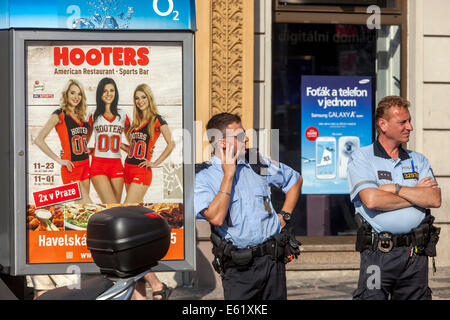 Straßenplakat auf dem Restaurant Hooters, tschechischer Polizeibeamter auf Patrouille, Prag, tschechischer Polizeibeamter auf Straßenpatrouille in Sommeruniform Stockfoto