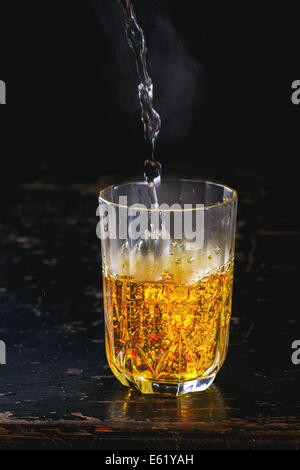 Vintage Glas mit Safran Blumen und gießt heißes Wasser Stockfoto