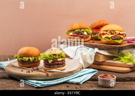 Fünf verschiedene Gourmet-Burger auf hölzernen Hintergrund Stockfoto