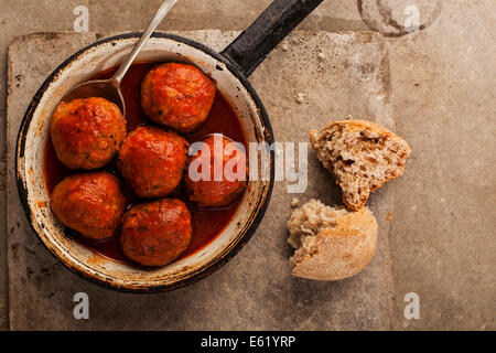 Fleischbällchen in Tomatensauce in Pfanne auf grauem Hintergrund gekocht Stockfoto