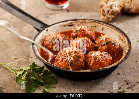 Fleischbällchen in Tomatensauce in Pfanne auf grauem Hintergrund gekocht Stockfoto
