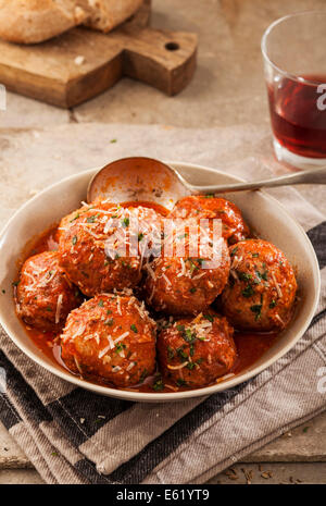 Fleischbällchen in Tomatensauce in Schüssel auf grauem Hintergrund gekocht Stockfoto