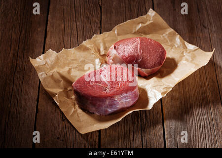 Rohes Rindfleischsteak auf dem Holztisch. Stockfoto