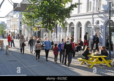 Menschen, Geschäfte, Seite zu Fuß Restaurants und Pubs in Laugavegur Straße im Zentrum von Reykjavik an einem sonnigen Tag in Island Stockfoto