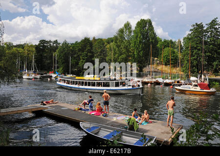 Ausflugsboote und Kajakfahrer auf Långholmen Långholmen Kanal mit Sonnenanbeter in Stockholm Stockfoto