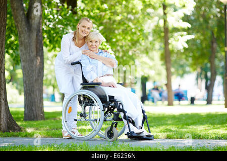 Hübsche Krankenschwester kümmert sich um ältere Patienten im Rollstuhl Stockfoto