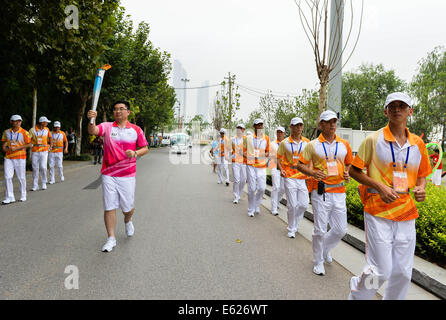 (140812)--NANJING, Aug.12, 2014(Xinhua)--Fackelträger Zhang Haoran hält die Flamme während der Fackellauf der Nanjing 2014 Youth Olympic Games in Nanjing, der Hauptstadt der ostchinesischen Provinz Jiangsu, auf August.12, 2014.Nanjing 2014 Olympischen Jugend-Winterspiele von 16 bis 28 August stattfinden wird. (Xinhua/Li Xiang) (Lyq) Stockfoto