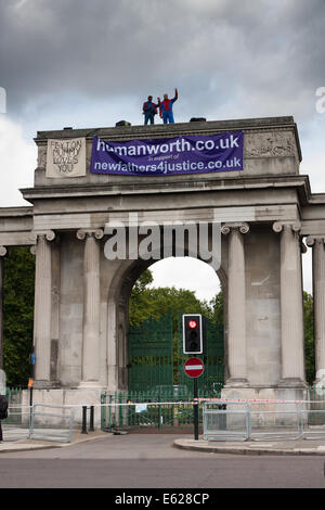 London, 12. August 2014. Zwei Demonstranten von Väter für Gerechtigkeit Welle an den Durchgangsverkehr aus Spitze Decimus Burtons Ionischen Bildschirm Eingang zum Hyde Park angrenzend an Apsley House am Hyde Park Corner. Bildnachweis: Paul Davey/Alamy Live-Nachrichten Stockfoto