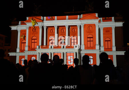 Zürich, Schweiz. 11. August 2014. Besucher schauen Sie sich die dreidimensionale Videoprojektion auf der neoklassizistischen Fassade des Opernhauses in der Innenstadt von Zürich, Schweiz, 11. August 2014. Die Videoprojektion thematisiert "Leichtathletik und Künste" und wurde in einem Jointventure von Zürcher kollektive "PROJEKTIL" und der Künste mit Sitz in Wien konzipiert kollektive "Lichttapete". Ihre video-Projektionen werden jeden Abend während der Europäischen Leichtathletik Weltmeisterschaften 2014 vorgestellt. Foto: Rainer Jensen/Dpa/Alamy Live-Nachrichten Stockfoto