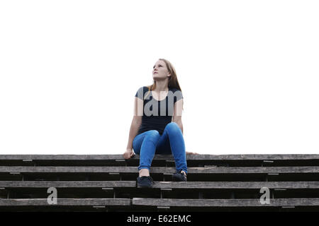 nachdenkliche junge Frau sitzt auf freien Flug der Treppe Stockfoto