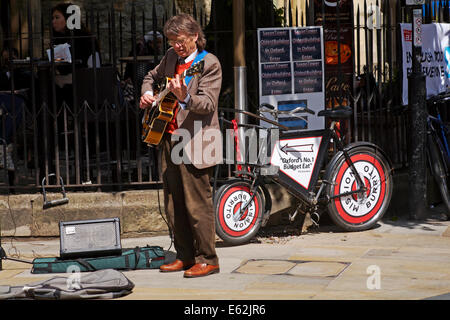 Straßenmusiker, der im Mai in Oxford, Oxfordshire, Großbritannien, Gitarre spielt Stockfoto