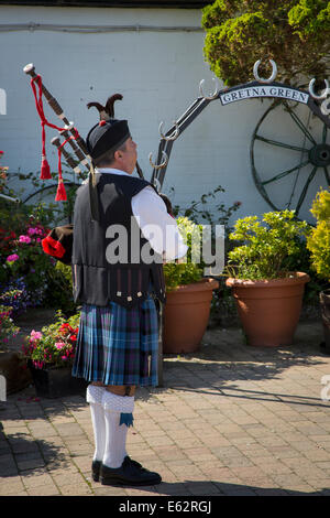 Schottische Piper in der alten Schmiede in Gretna Green, Dumfries and Galloway, Schottland, Großbritannien Stockfoto