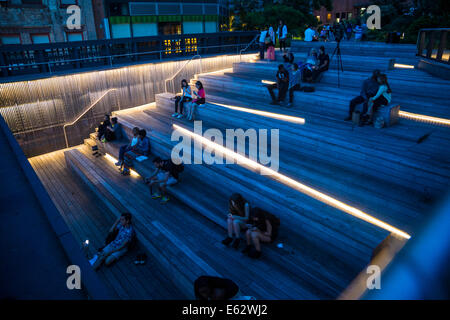 Manhattan, New York. Leute sitzen in der Abenddämmerung auf der Anzeige ein Ansporn der Highline Park am 26th Street. Stockfoto