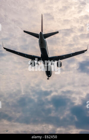 Passage Airline Jet absteigend Landeanflug gegen einen dramatischen Hintergrund der sonnenbeschienenen Wolken. Atlanta, Georgia. (USA) Stockfoto