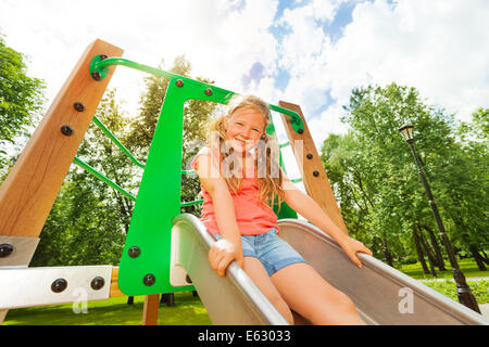 Lustiges Mädchen auf Kinder Rutsche bereit zu schieben Stockfoto