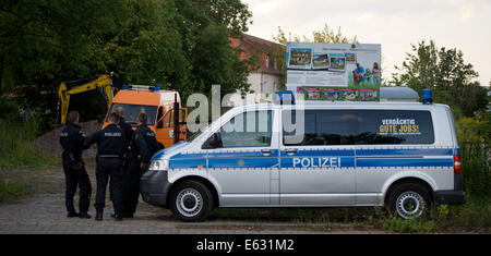 Dresden, Deutschland. 12. August 2014. Polizisten, einen Polizeiwagen und ein Fahrzeug des Referats Bombe zur Verfügung stehen auf dem Gelände, wo eine US-Flugzeug Bombe des zweiten Weltkriegs in Dresden, Deutschland, 12. August 2014 gefunden wurde. Blindgänger, ein US-Flugzeug Bombe mit einem Gewicht von fünf Zentner, fand man bei Aushubarbeiten, örtliche Polizei erklärte. Bildnachweis: Dpa picture Alliance/Alamy Live News Stockfoto