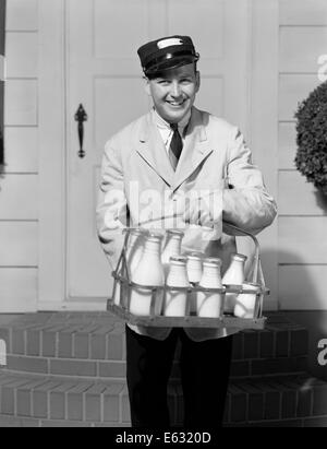 1930ER JAHREN LÄCHELND MILCHMANN BLICK AUF KAMERA LIEFERN MILCH IN GLASFLASCHEN BIS VOR DIE HAUSTÜR Stockfoto