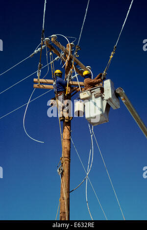 ZWEI TELEFON LINEMEN ARBEITEN AN OBERLEITUNGEN Stockfoto