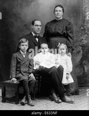 1890ER JAHREN FORMALE STUDIOPORTRAIT VON DREI KINDER DER FAMILIE VATER MUTTER SOHN TOCHTER BABY Stockfoto