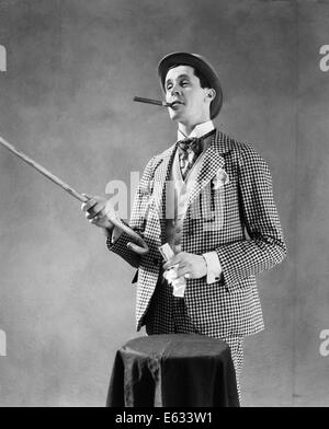 1910S 1920S CHARAKTER HOCHSTAPLER BARKER BOWLER HUT LAUT VAUDEVILLE ART KLEIDUNG ZEIGEN CANE HOLDING GELD RAUCHENDE ZIGARRE Stockfoto