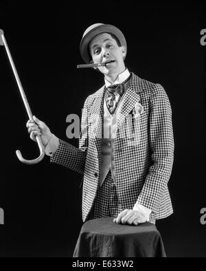 1910S 1920S HOCHSTAPLER BARKER BOWLER HUT LAUT VAUDEVILLE ZEICHENTYP KLEIDUNG ZEIGENDEN CANE RAUCHEN ZIGARRE VERTRAUEN SPIEL Stockfoto