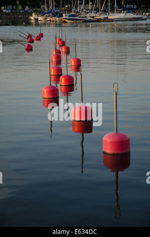 Reihe von roten Bojen im Wasser reflektiert Stockfoto