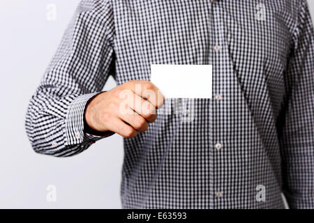 Hand des Mannes zeigt Visitenkarte - Closeup erschossen auf grauem Hintergrund Stockfoto