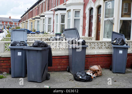 Mehrere überlaufen Wheelie bins außerhalb eines Hauses in einem Vorort Straße Stockfoto