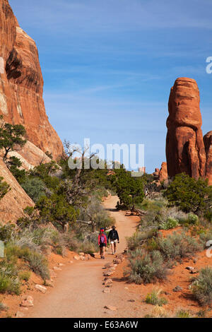 Sandstein-Formationen und Wanderer am Weg zum Landscape Arch, des Teufels Gartenbereich des Arches-Nationalpark in der Nähe von Moab, Utah, USA Stockfoto