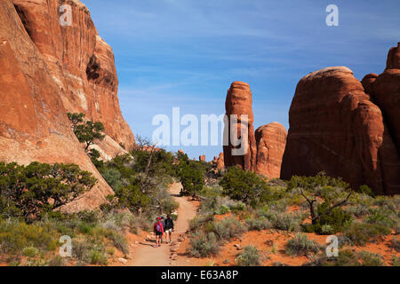 Sandstein-Formationen und Wanderer am Weg zum Landscape Arch, des Teufels Gartenbereich des Arches-Nationalpark in der Nähe von Moab, Utah, USA Stockfoto