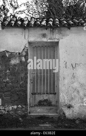 Rostige Tür und strukturierte Wand. Verlassenes Haus von außen. Stockfoto