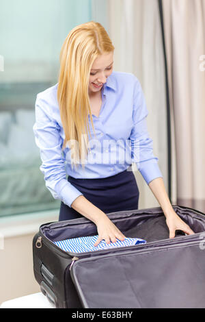 Geschäftsfrau Verpackung Dinge im Koffer Stockfoto