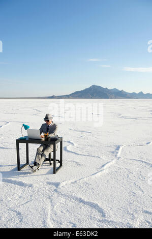 Geschäftsmann, arbeiten an Inspiration am Schalter im Freien auf dramatische Weiße Wüste Landschaft Stockfoto