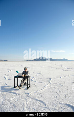 Geschäftsmann, arbeiten an Inspiration am Schalter im Freien auf dramatische Weiße Wüste Landschaft Stockfoto