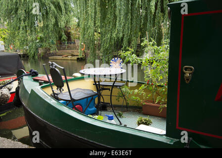 Leiten Sie Bestandteil einer grünen Hausboot am Regents Kanal mit Tisch und Stühlen. Überhängenden Weide im Hintergrund Stockfoto