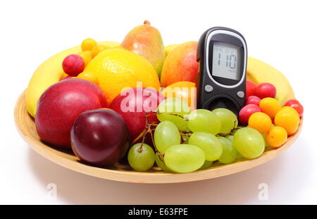 Frische reife Früchte und Glukose Meter liegen auf Holzplatte, Konzept für gesunde Ernährung und Diabetes. Isoliert auf weißem Hintergrund Stockfoto