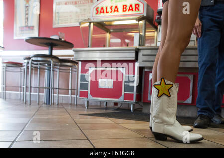 Frau Cowboystiefel trägt mit Carls Jr. Restaurants-Logo in einer Lage von Austin, Texas Stockfoto