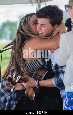 Toronto, Kanada. 13. August 2014. Ein Fan gelungen, Sicherheit zu umgehen und auf der Bühne mit Mendes zu springen. Sechzehn Jahre alten kanadischen Teenie Musiker Shawn Mendes ein Ständchen Fans bei einem Auftritt im Vorort Toronto Scarborough. Bildnachweis: Victor Biro/Alamy Live-Nachrichten Stockfoto