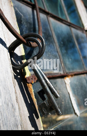alte antike Schlüssel gegen einen gefärbten verbleit, Fenster und Rahmen Stockfoto