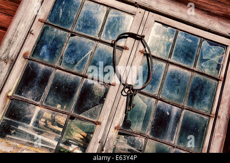 alte, antike Schlüssel und ring hängen gegen verfärbte Bleiglasfenster und Rahmen, 17. Jahrhundert Konzept Stockfoto