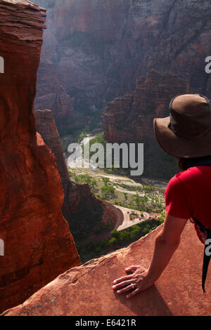 Wanderer auf der Suche von steilen Klippe in Zion Canyon von Scout Lookout, Angels Landing Track, Zion Nationalpark, Utah, USA Stockfoto