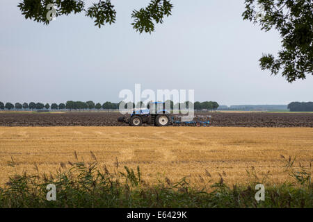 Traktor Pflügen das Land in Nieuw-Scheemda, Provinz Groningen, Niederlande Stockfoto