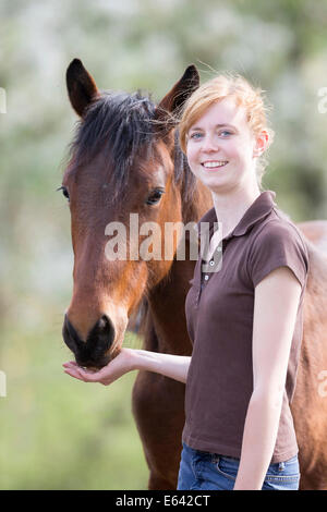 Junge Frau stand neben einem American Quarter Horse. Deutschland Stockfoto