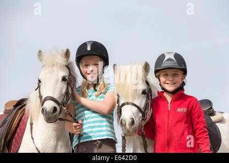 Shetland-Pony. Zwei Mädchen Ponys am Zügel halten. Deutschland Stockfoto