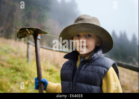 kleiner Junge mit Hacke Stockfoto