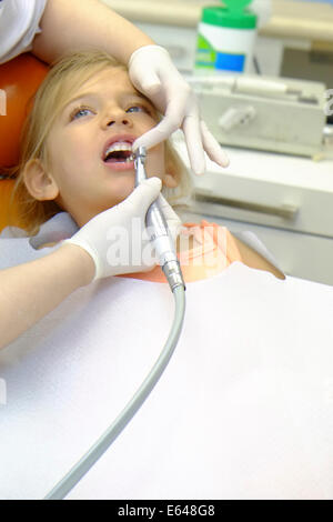 Junges Mädchen hat ihre Zähne gereinigt durch eine Dentalhygienikerin beim Zahnarzt Stockfoto