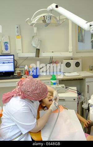 Junges Mädchen hat ihre Zähne gereinigt durch eine Dentalhygienikerin beim Zahnarzt Stockfoto